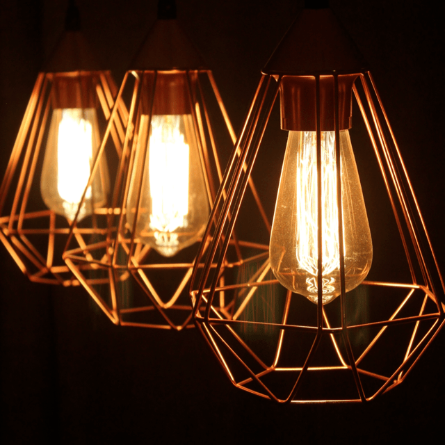 Three light bulbs in modern angular  wire frames.